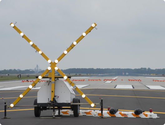 a yellow x shaped object on a runway